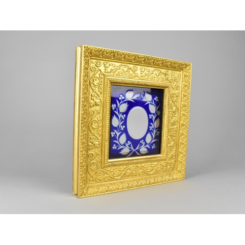 93 - A Gilt Frame of Ornate Stepped Form having Blue Overlaid Glass Panel, 24x25cms