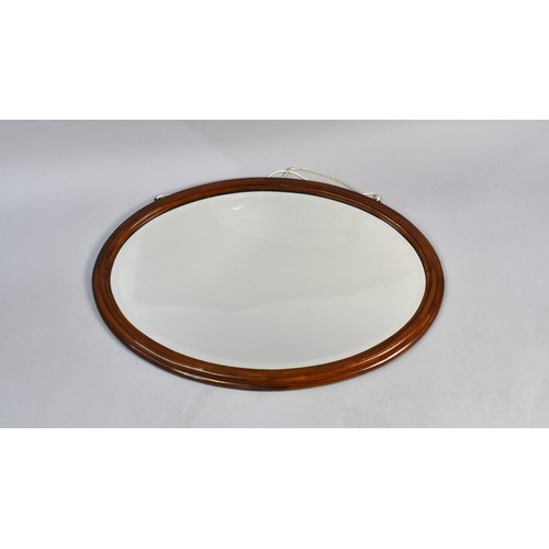 424 - A Mahogany Framed Oval Mirror with Bevelled Glass