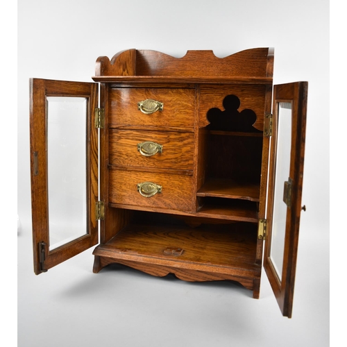 20 - An Edwardian Oak Smokers Cabinet with Glazed Doors to Fitted Interior having Three Drawers, Gallerie... 