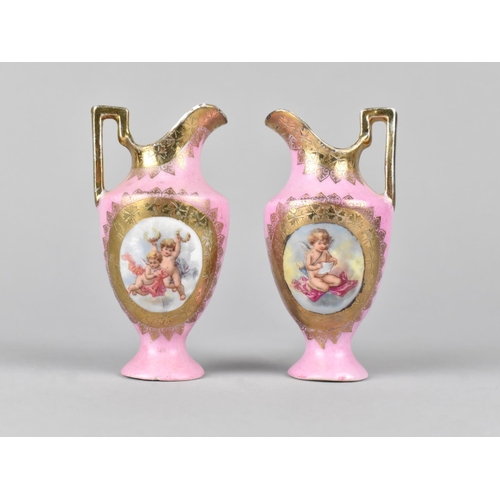 443 - A Small Pair of Continental Porcelain Ewers Decorated with Cherub Cartouches on Pink Ground, 9cm