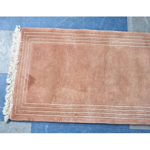 568 - A Short Woollen Runner on Pink Ground, 180x62cms