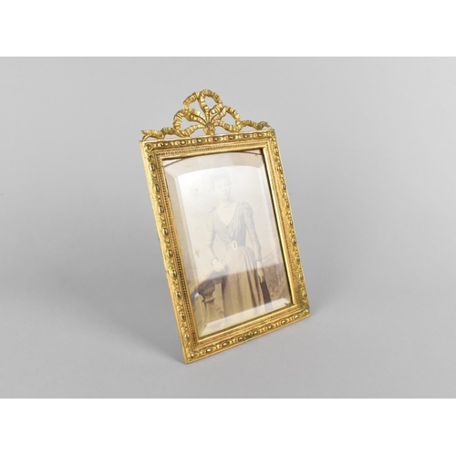 66 - A Pretty Gilt Metal Easel Back Photo Frame with Ribbon Finial, 13x21cms