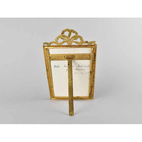 66 - A Pretty Gilt Metal Easel Back Photo Frame with Ribbon Finial, 13x21cms