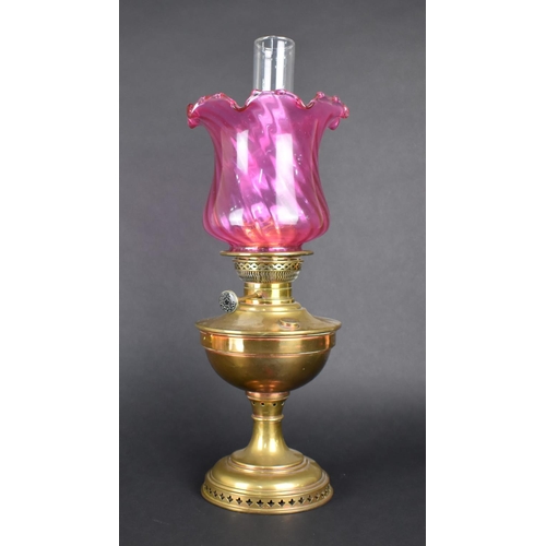 74 - An Early 20th Century Brass Oil Lamp with Cranberry Glass Shade and Plain Glass Chimney, 57cms High