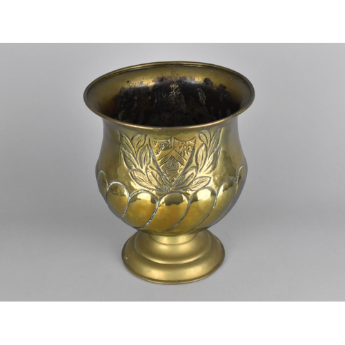 125 - A Brass Vase with Heraldic and Laurel Leaf Decoration in Relief, 19.5cms Diameter and 23cms High