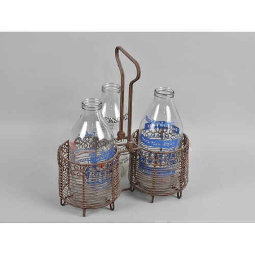 177 - A Vintage Wire Two Bottle Milk Carrier with Three Decorated Milk Bottles