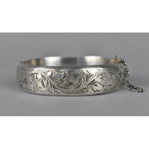 430 - A Silver Bangle with Floral Border and Safety Chain, Hallmark R.P.H. Birmingham 1967