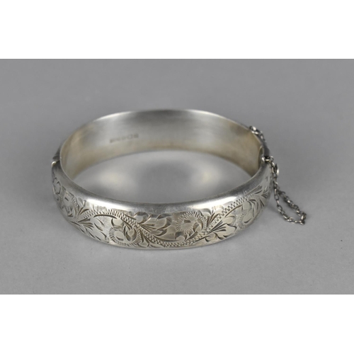 430 - A Silver Bangle with Floral Border and Safety Chain, Hallmark R.P.H. Birmingham 1967