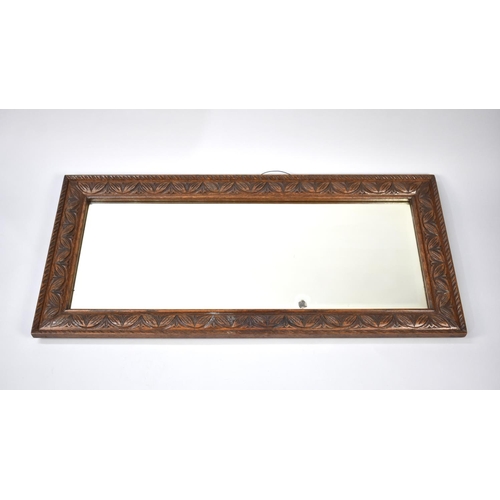 477 - A Mid 20th Century Carved Oak Framed Wall Mirror, 105cms by 50cms