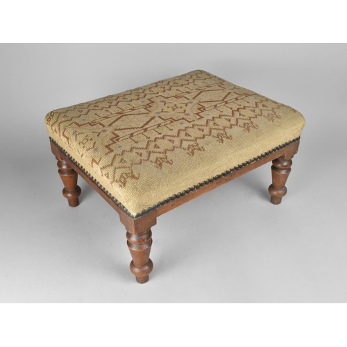 80 - A Tapestry Upholstered Rectangular Footstool with Turned Mahogany Supports, 40cms Long