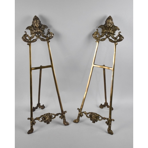 153 - A Pair of Large French Style Brass Easel Stands with Mask Decoration, 60cms High