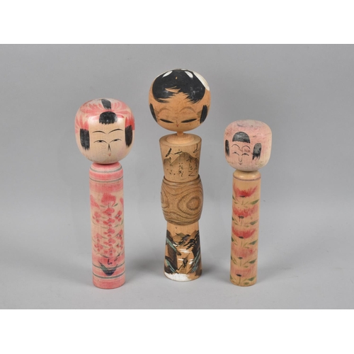 170 - A Graduated Set of Three Painted Wooden Kokeshi Dolls