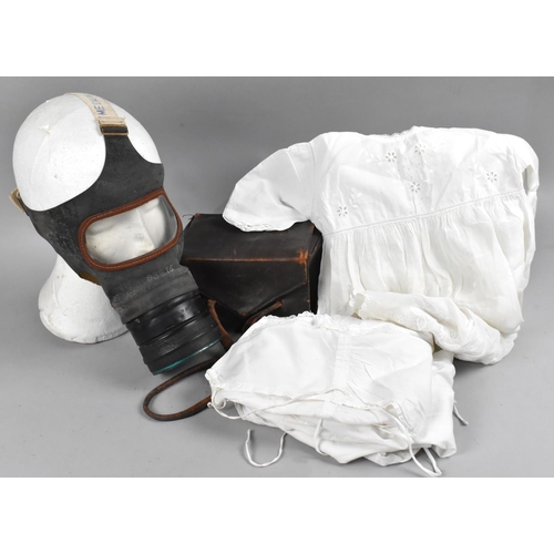 173 - A Leather Cased WWII Gas Mask together with Three Babies Christening Gowns and an Undershirt