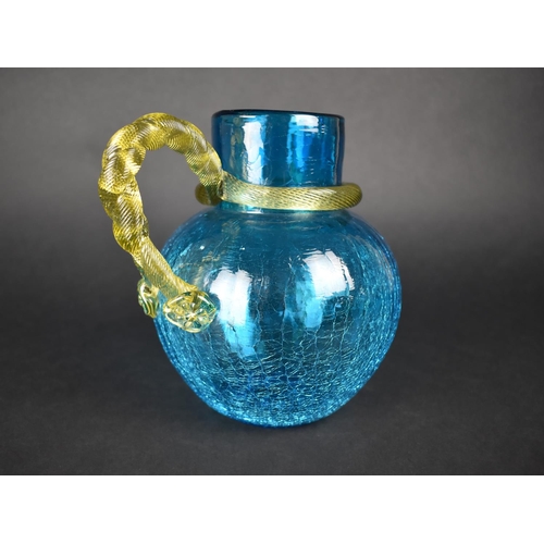 403 - A Blue Crackle Glass Jug with with Yellow Interlaced Reeded Handle, 18.5cm high