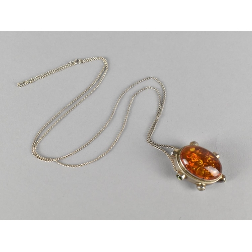 426 - A Silver Mounted Pendant with Amber Cabochon Set Along with Three Small Peridot and Three Moonstone ... 