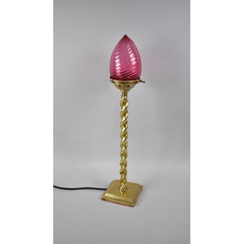 62 - An Edwardian Brass Barley Twist Table Lamp with Cranberry Glass Shade, 68cms High