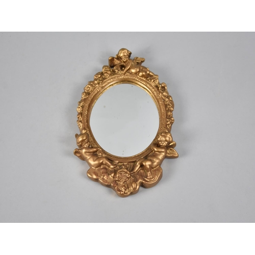 93 - A Modern Moulded Gilt Framed Oval Wall hanging Mirror with Cherub Finial, 23cms High