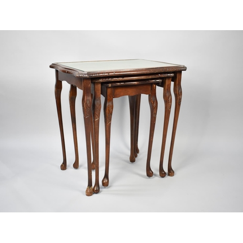 98 - A Late 20th Century Mahogany Framed Nest of Three Tables with Tooled Leather Panel Tops, 54cms Wide