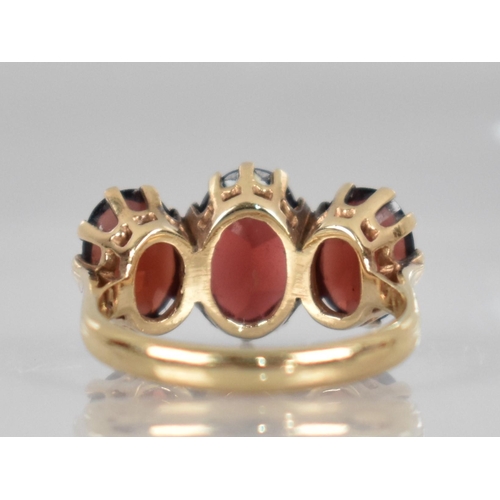 74 - A 9ct Gold and Garnet Dress Ring, Central Oval Cut Stone Measuring 9.9mm by 6.5mm, Claw and Tension ... 