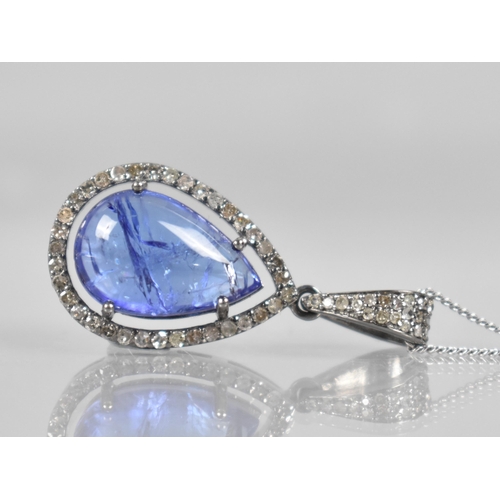 111 - A Tanzanite and Diamond Set Pendant, Central Pear Shaped Cabochon Tanzanite Measuring Approx 4.90ct,... 