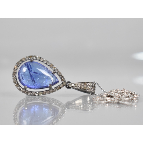 111 - A Tanzanite and Diamond Set Pendant, Central Pear Shaped Cabochon Tanzanite Measuring Approx 4.90ct,... 