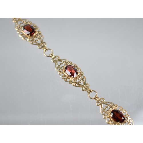 91 - A 9ct Gold and Garnet Six Panel Bracelet, Each Panel with Oval Cut Stone Measuring 7.1mm by 5mm, Set... 