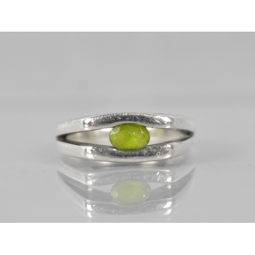 217 - A Heavy Modernist Peridot and Silver Ring with Oval Cut Stone Measuring 5.6mm by 3.3mm, Tension Set ... 