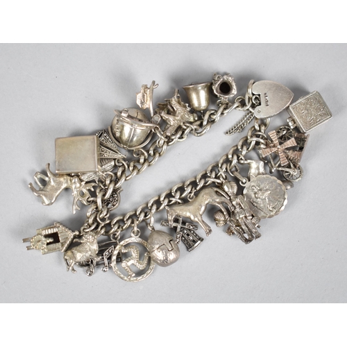 233 - A Heavy Silver Charm Bracelet, Curb Link Chain with 19 Various Charms to include Articulated Egg, To... 