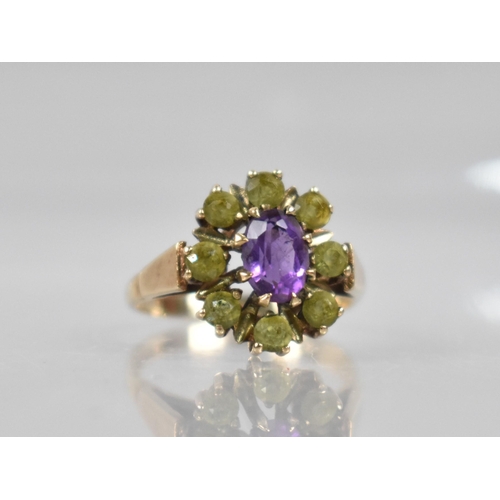 73 - A 9ct Gold, Amethyst and Peridot Ring, Central Oval Cut Amethyst Measuring 7mm by 5.1mm in Eight Cla... 