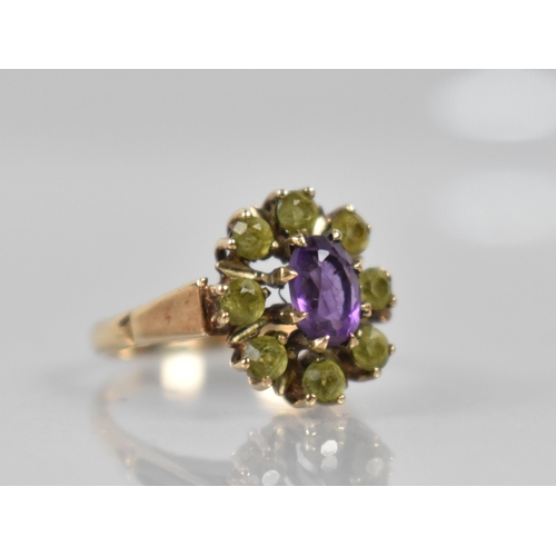 73 - A 9ct Gold, Amethyst and Peridot Ring, Central Oval Cut Amethyst Measuring 7mm by 5.1mm in Eight Cla... 