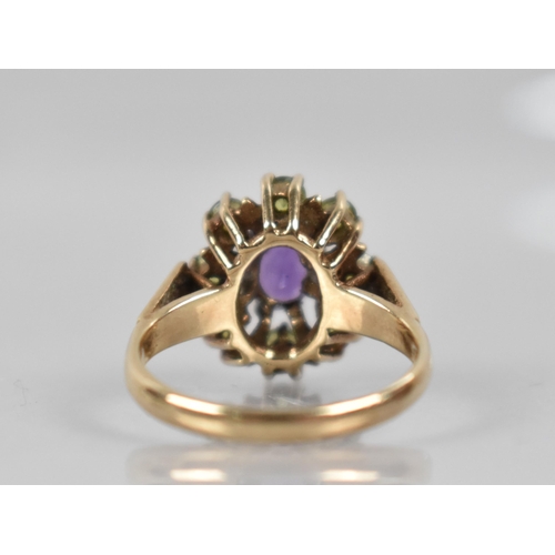 73 - A 9ct Gold, Amethyst and Peridot Ring, Central Oval Cut Amethyst Measuring 7mm by 5.1mm in Eight Cla... 