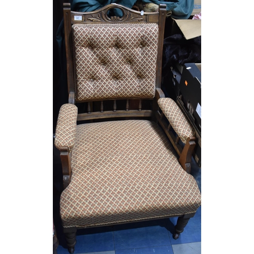 507 - An Edwardian oak and Upholstery Button Back Armchair with Carved top and Spindle Supports Raised on ... 