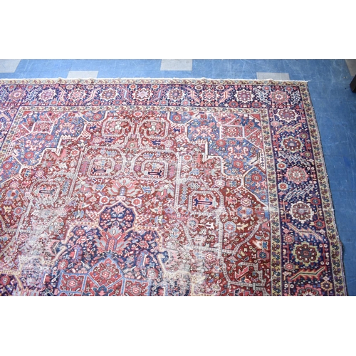 531 - An Early 20th Century Handmade Persian Heriz Pattern Carpet on Red Ground, C.1910, 390x298cm