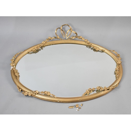 84 - An Edwardian Oval Wall Hanging Gilt Framed Mirror with Floral Swag and Ribbon Decoration, Condition ... 