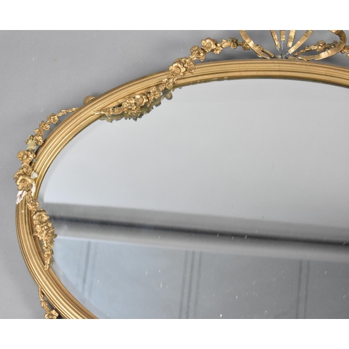 84 - An Edwardian Oval Wall Hanging Gilt Framed Mirror with Floral Swag and Ribbon Decoration, Condition ... 