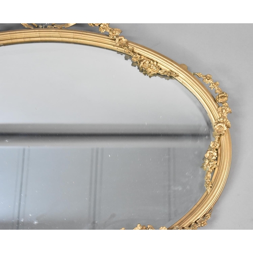 84 - An Edwardian Oval Wall Hanging Gilt Framed Mirror with Floral Swag and Ribbon Decoration, Condition ... 