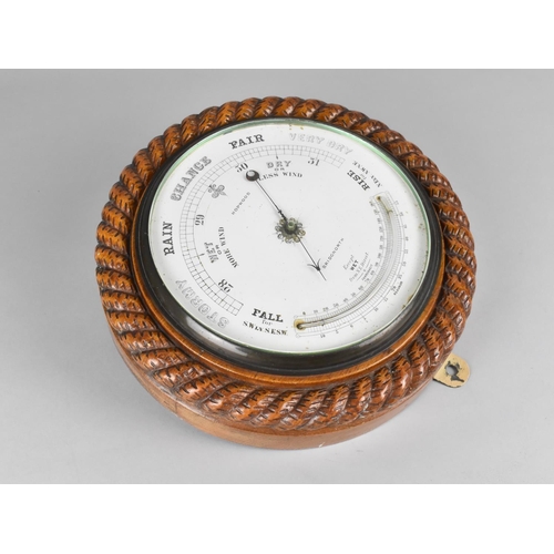 24 - An Edwardian Circular Wall Hanging Aneroid Barometer with Carved Oak Rope Border, White Enamelled Di... 