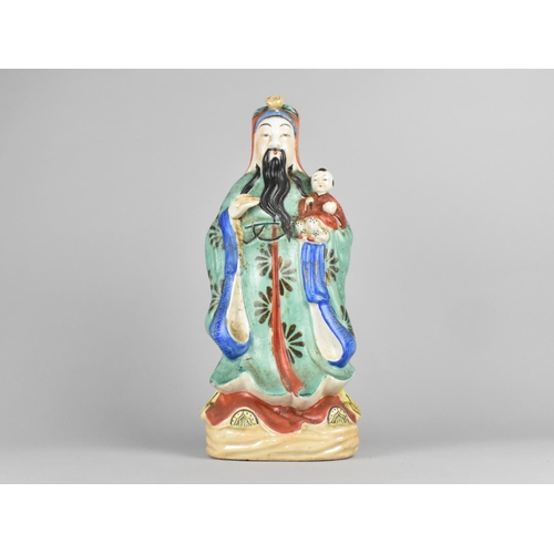 86 - A Chinese Porcelain Study of Deity Holding Child, 39cms High