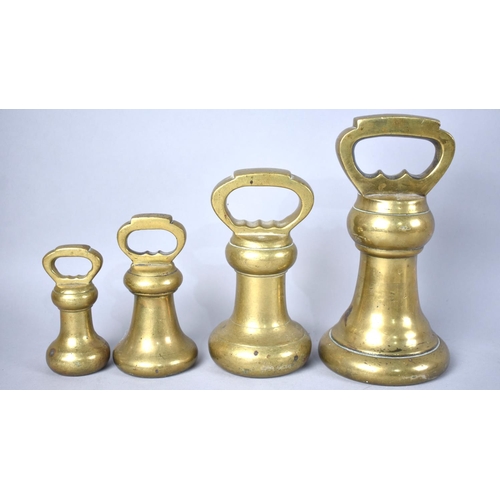 137 - An Unrelated Graduated Set of Four Brass Bell Weights, Heaviest 100oz, 18cms High