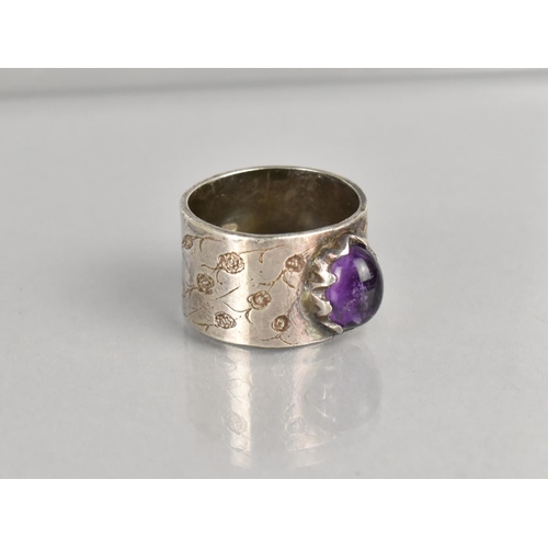 467 - A Silver Ring having Oval Cabochon Amethyst Stone on a Wide Textured Band, Stamped Internally MJR, S... 