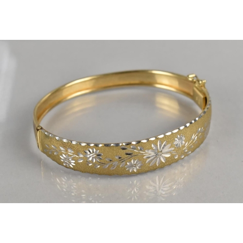 473 - A 9ct Gold Hinged Bangle, Textured Front with Incised Two Tone Decoration depicting Flowers, Push Cl... 