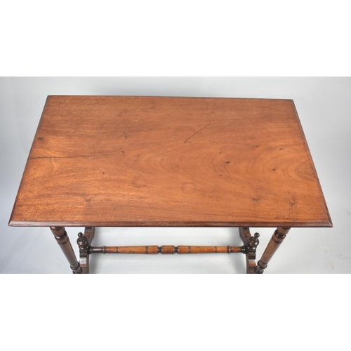 50 - An Edwardian Mahogany Rectangular Occasional Table with turned Supports and Stretcher, 73cms by 44cm... 