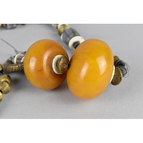 483 - A Far Eastern Type Beaded Necklace Housing Two Large Amber Coloured Beads, Requires Restringing