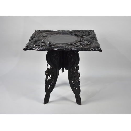 70 - A Carved Ebonized Chinese Table Decorated in High Relief with Dragons, 67cms Square, Folding Carved ... 