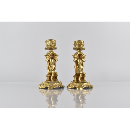 138 - A Pair of Ormolu Candlesticks, Modelled with Seated Cherub in Architectural Arch on Scrolled Acanthu... 