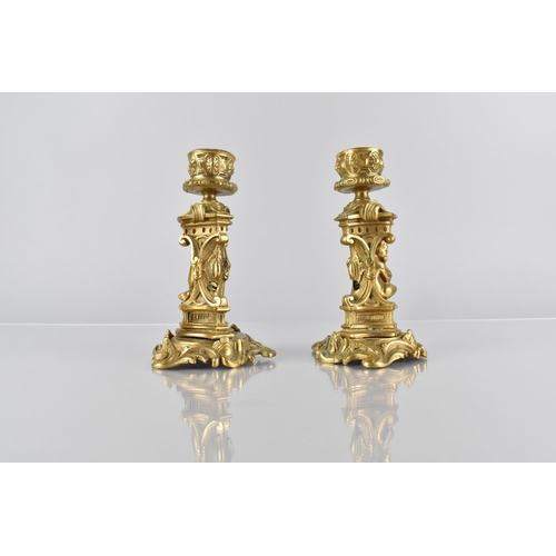 138 - A Pair of Ormolu Candlesticks, Modelled with Seated Cherub in Architectural Arch on Scrolled Acanthu... 