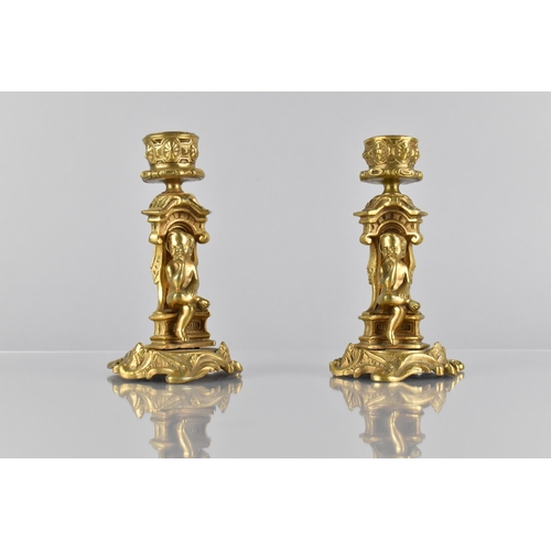 138 - A Pair of Ormolu Candlesticks, Modelled with Seated Cherub in Architectural Arch on Scrolled Acanthu... 