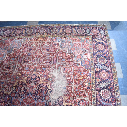 200 - WITHDRAWN: An Early 20th Century Handmade Persian Heriz Pattern Carpet on Red Ground, C.1910, 390x29... 