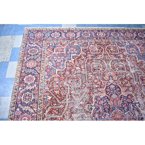 200 - WITHDRAWN: An Early 20th Century Handmade Persian Heriz Pattern Carpet on Red Ground, C.1910, 390x29... 