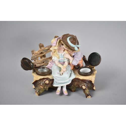 37 - A Continental Novelty Desktop Ink Stand with Two Inkwells, Decorated with Young Boy and Girl Kissing... 